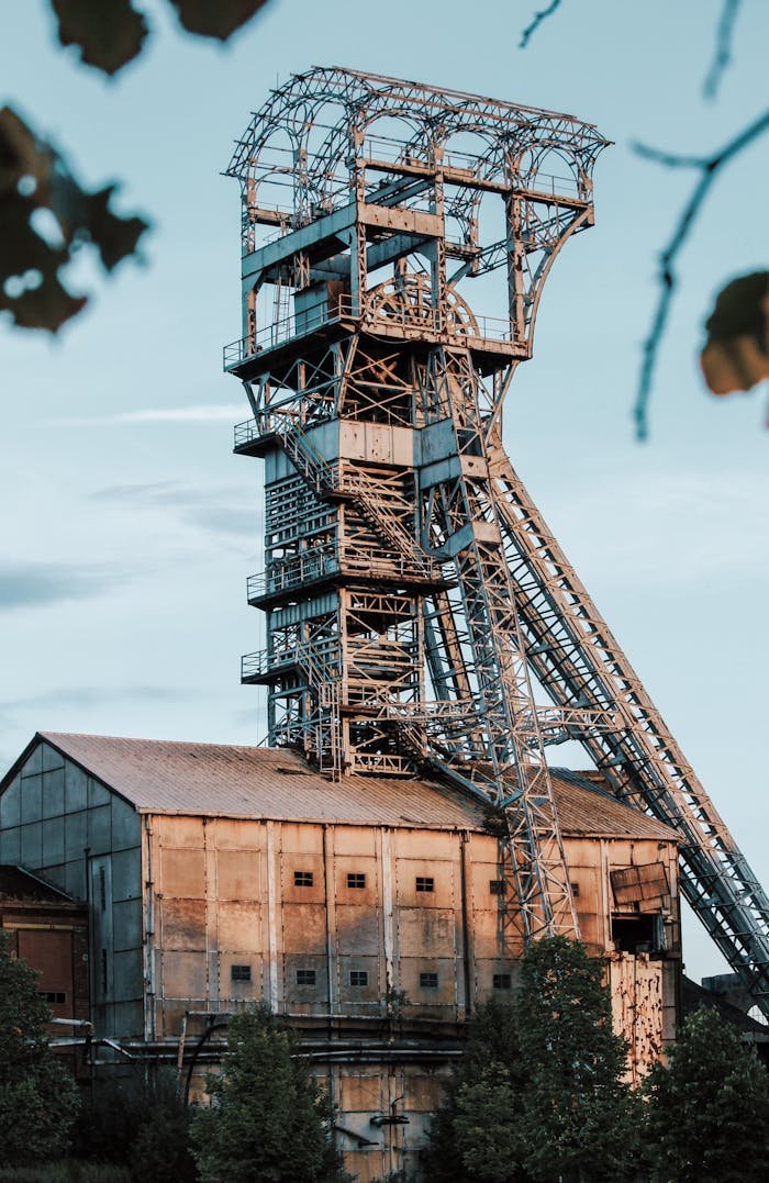 Rusty industrial mining tower in Heusden-Zolder, Belgium during daylight.