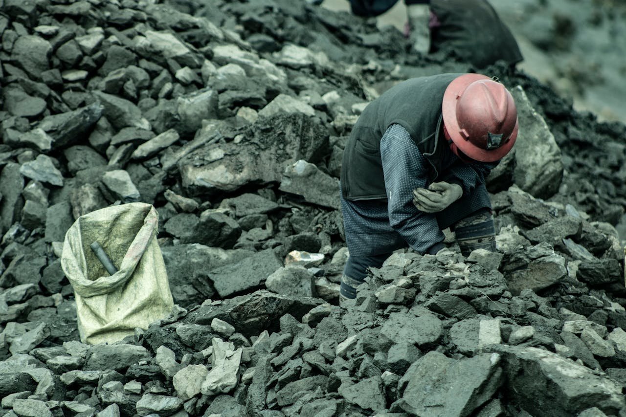 A woman mining for gold in La Rinconada, Peru, surrounded by rocks and debris.